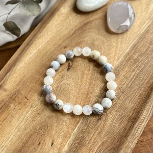 Intuíció és egyensúly karkötő egy fa tálcán, mellette egy marokkővel.